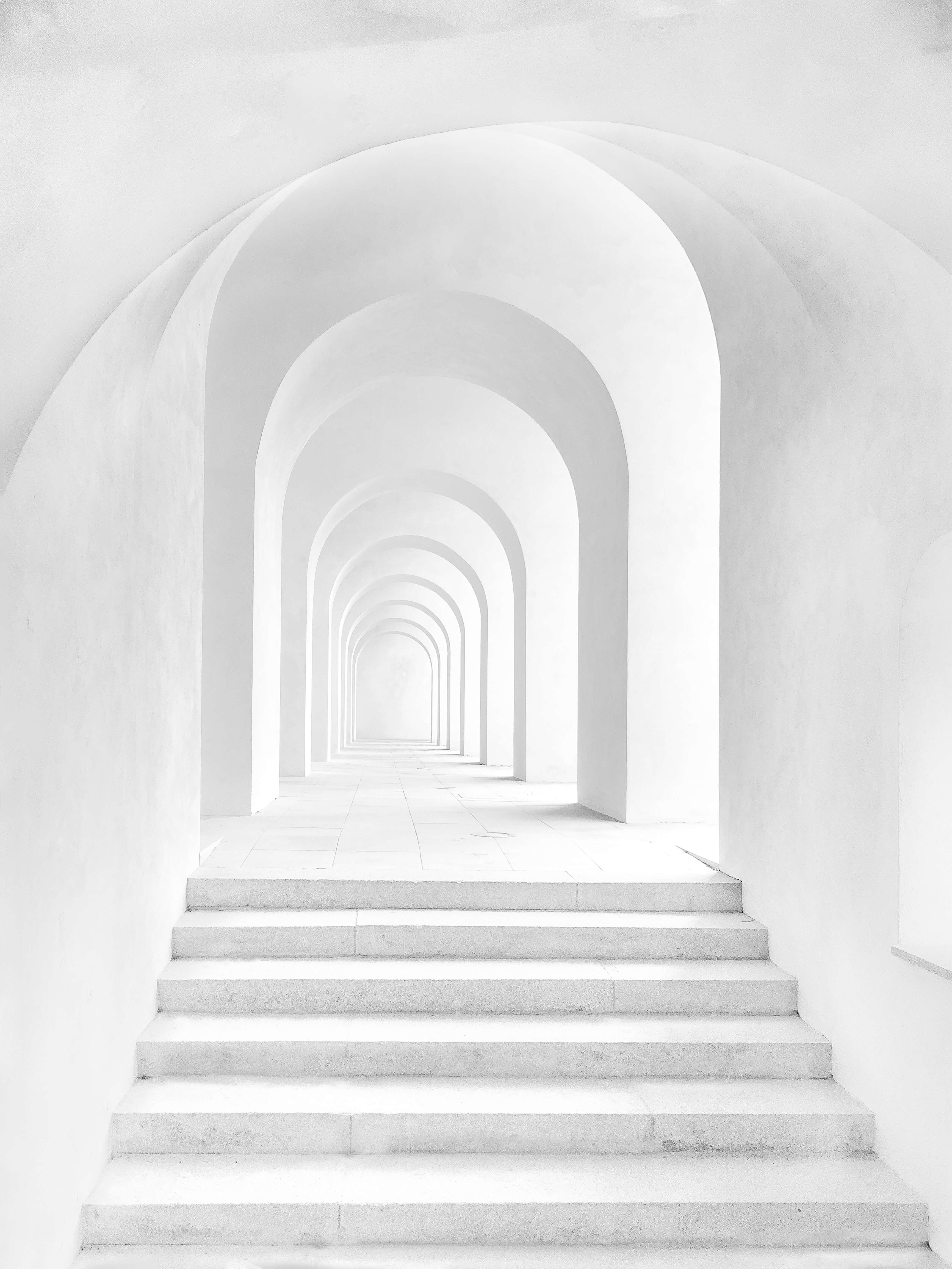 white arched hallway with stairs